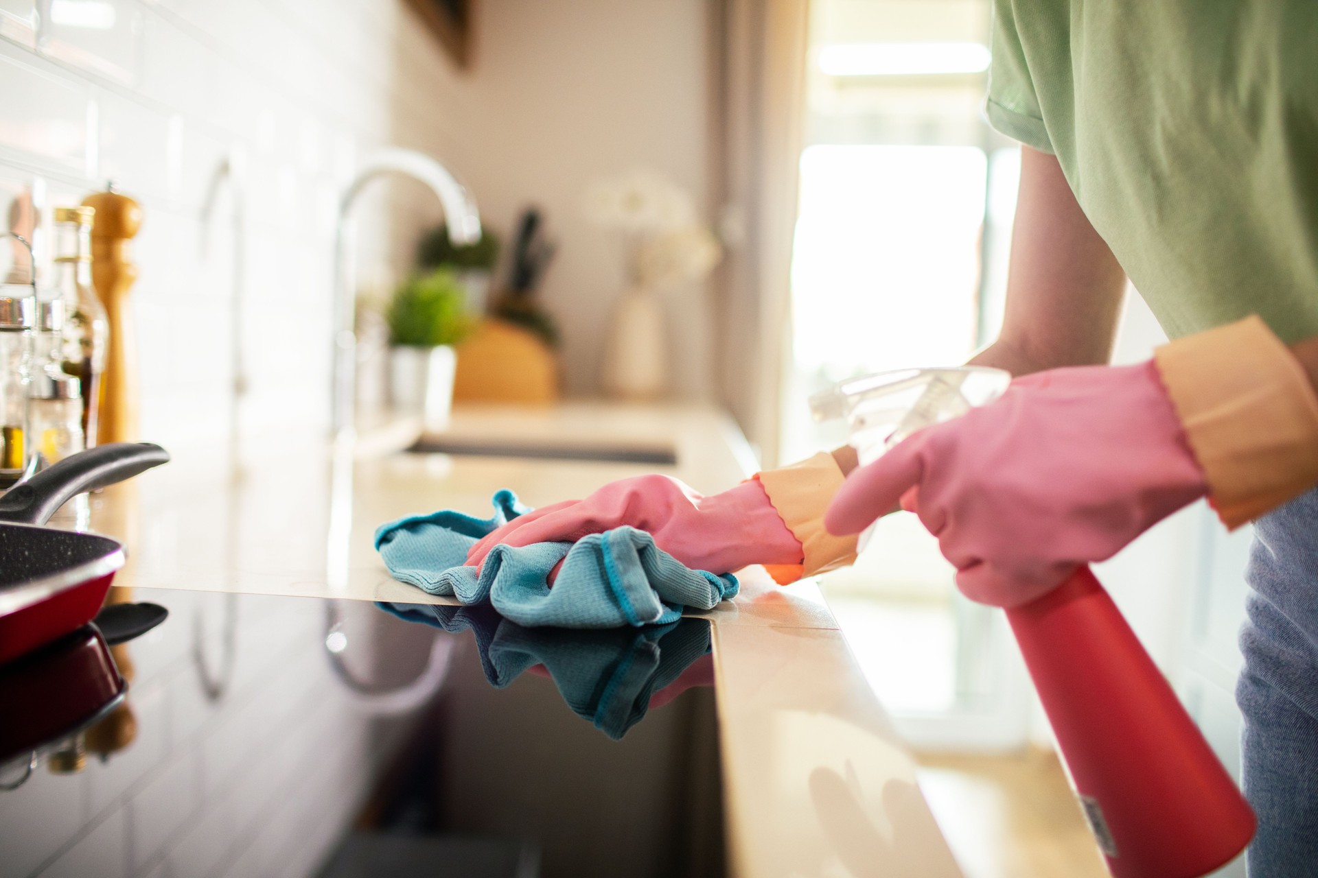 Young woman cleaning the kitchen in her home